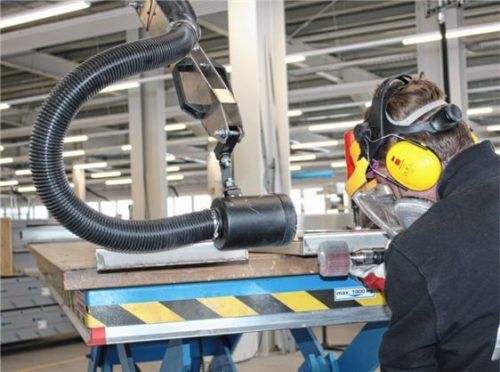 Direkt am Arbeitsplatz saugt der schwarze, bewegliche Schlauch (links) den Schleifstaub am Arbeitsplatz in der Werkstatt bei Halton Foodservice ab. Foto re