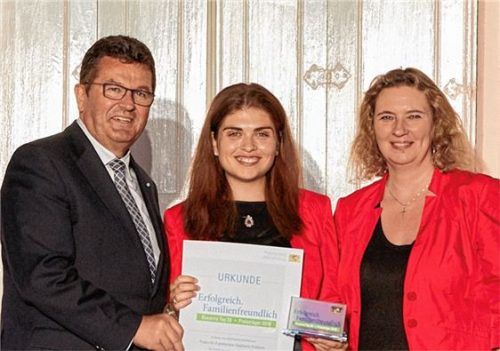 Trophäe und Urkunde haben Wirtschaftsminister Franz Josef Pschierer und Familienministerin Kerstin Schreyer (rechts) an Stephanie Pollmann von der gleichnamigen Ergotherapie-Praxis in Waldkraiburg überreicht. Fotos StMAS