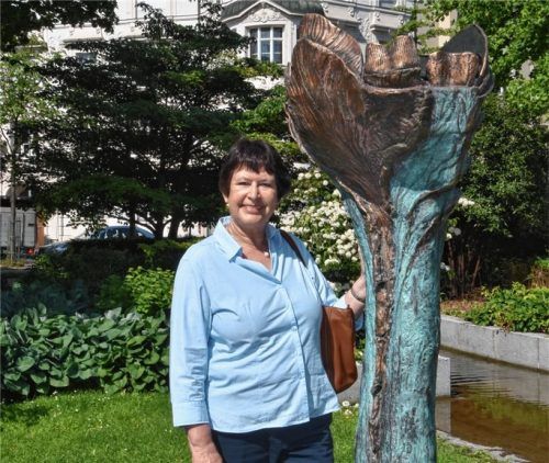 OVB-Autorin Dr. Evelyn Frick vor dem von Antje Tesche- Mentzen geschaffenen Werk „Große Blüte“ im Riedergarten, Thema in Folge 92. Alt-Verleger Alfons Döser schenkte die Bronze-Skulptur 2004 zum 150. Jubiläum des OVB-Medienhauses der Stadt Rosenheim.Foto Schlecker