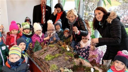 Mit viel Begeisterung beteiligen sich die Kleinen des Kindergartens St. Barbara mit selbst gebauten Figuren am Krippenweg. Hier bei der Aufstellung in der Sparkasse Kiefersfelden. Foto roc