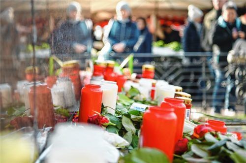 Kerzen und Blumen liegen am Brüder-Grimm-Denkmal am Marktplatz in Hanau, um an die Opfer der Bluttat zu erinnern.Foto dpa